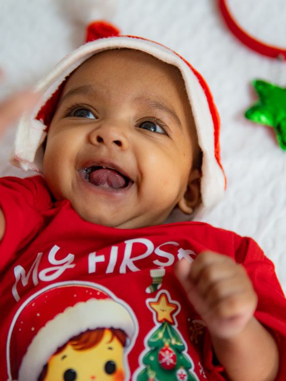 happy baby wearing a santa hat celebrating first christmas