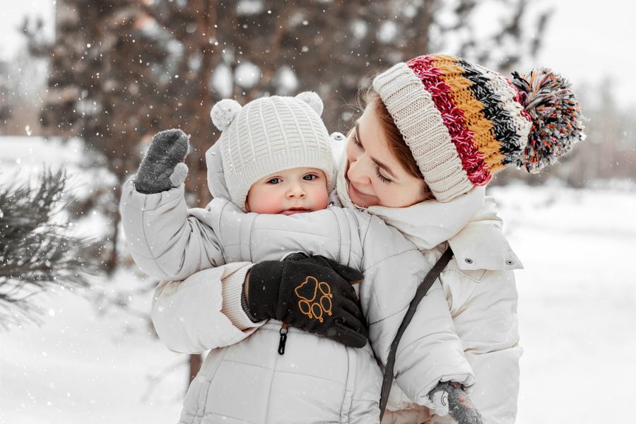 Mother and baby dressed for cold weather enjoying time together in the snow